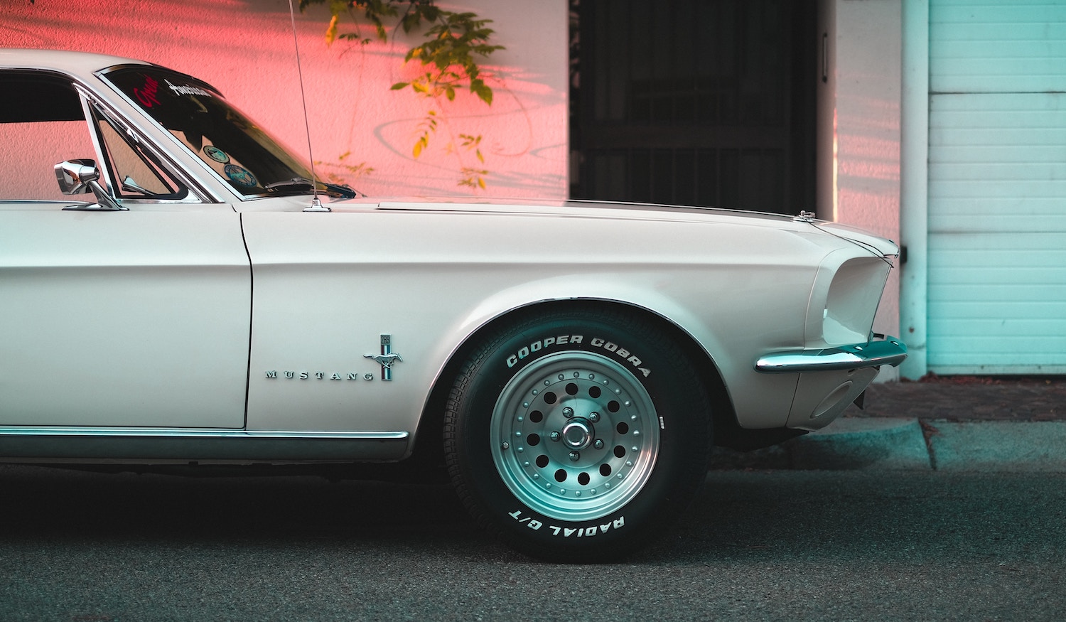 The front fender on a classic white Ford Mustang.