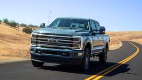 A fully loaded 2023 Ford F-350 Limited travels on a two-lane rural highway
