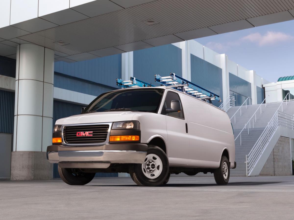 A GMC Savana cargo van on display outside an office.