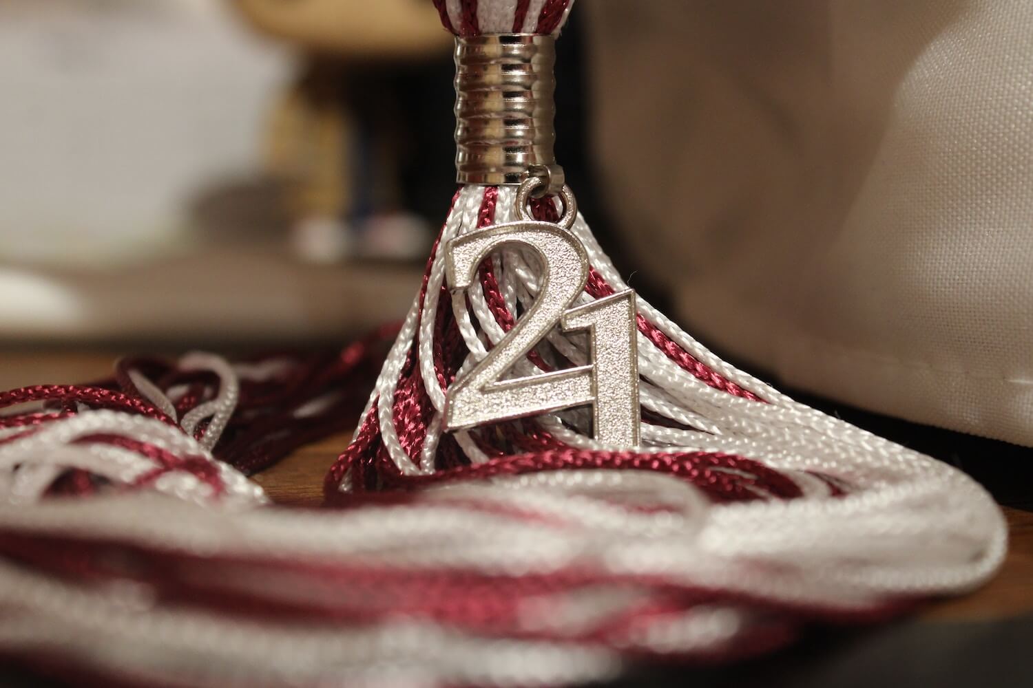 Closeup of a a graduation tassel with the number "21" attached to it.