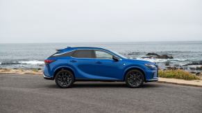 A side profile shot of a 2023 Lexus RX 350 F SPORT compact luxury SUV model with the Grecian Water color option