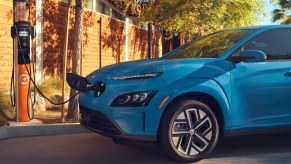A blue 2023 Hyundai Kona Electric is charging.