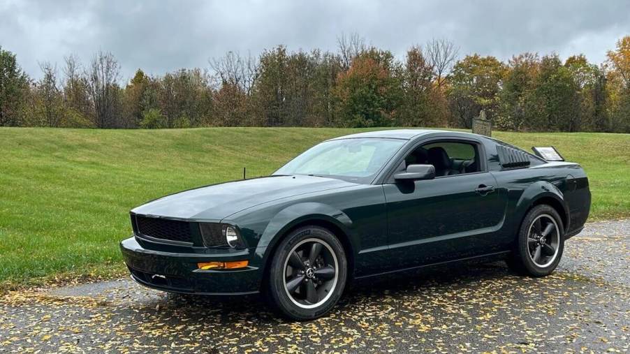 A 2008 Ford Mustang Bullitt in Dark Highland Green parks in a large lot.