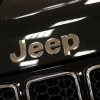 Closeup of the logo of a Jeep that is not American-made, but assembled in Italy instead.
