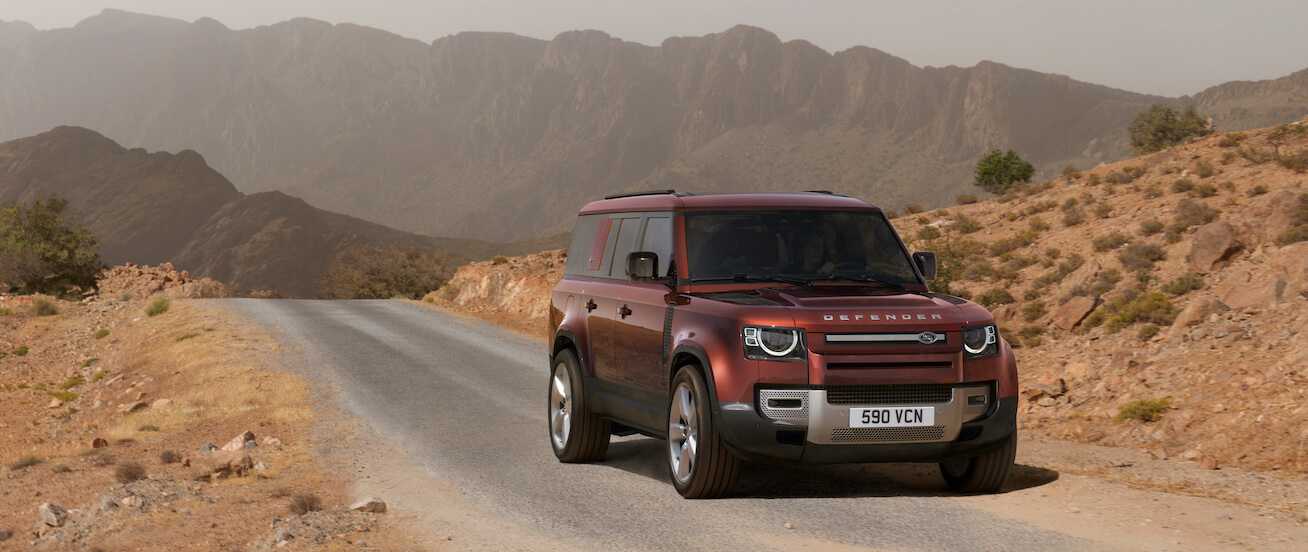 2023 Land Rover Defender in red on a road in the desert