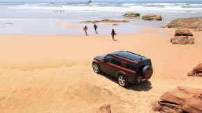 Crimson 2023 Land Rover Defender 130 parked at the beach