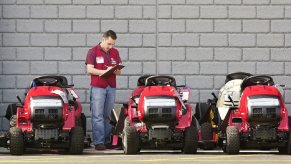 An employee inventories lawn mowers at a Lowes store.
