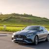 The Mercedes-Benz/Mercedes-AMG C 43 luxury compact sedan model driving past a grass hill of farm fields