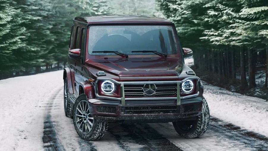 A burgundy 2023 Mercedes-Benz G-Class is parked on a snowy road.