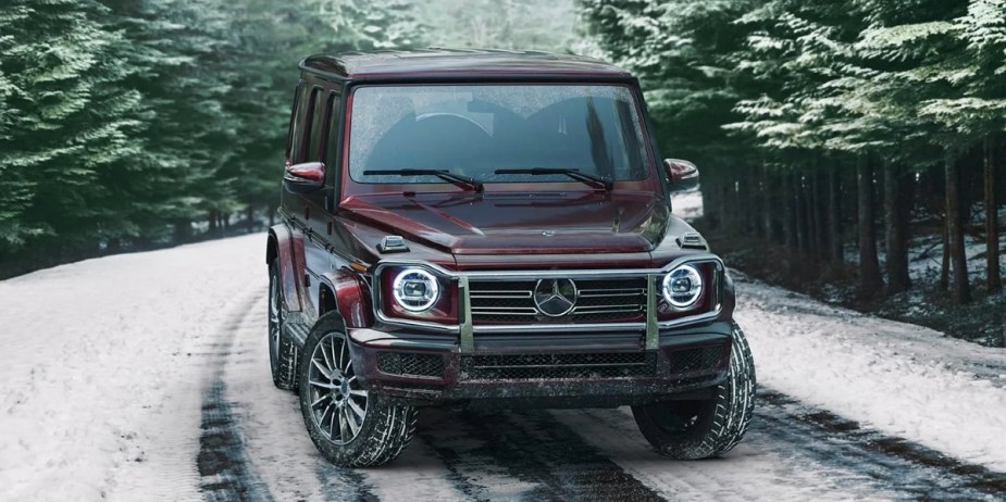 A burgundy 2023 Mercedes-Benz G-Class is parked on a snowy road. 