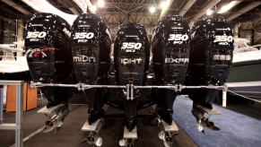 A collection of outboard motors attached to the back of a Midnight Express model at the New York National Boat Show