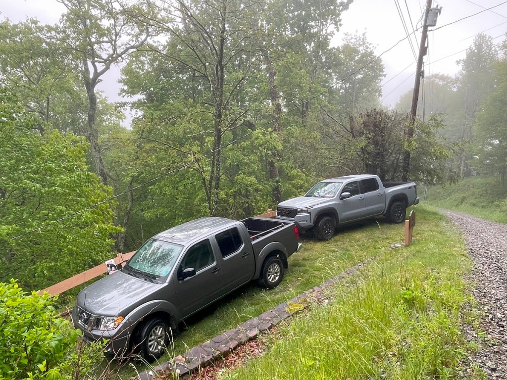 Two Nissan Frontier trucks parked in gravel