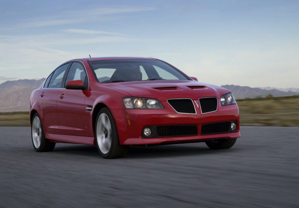 A Pontiac G8 drives down a road demonstrating a cheap used sports car Supra alternative.