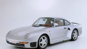 A silver 959 poses for a picture on a stage.