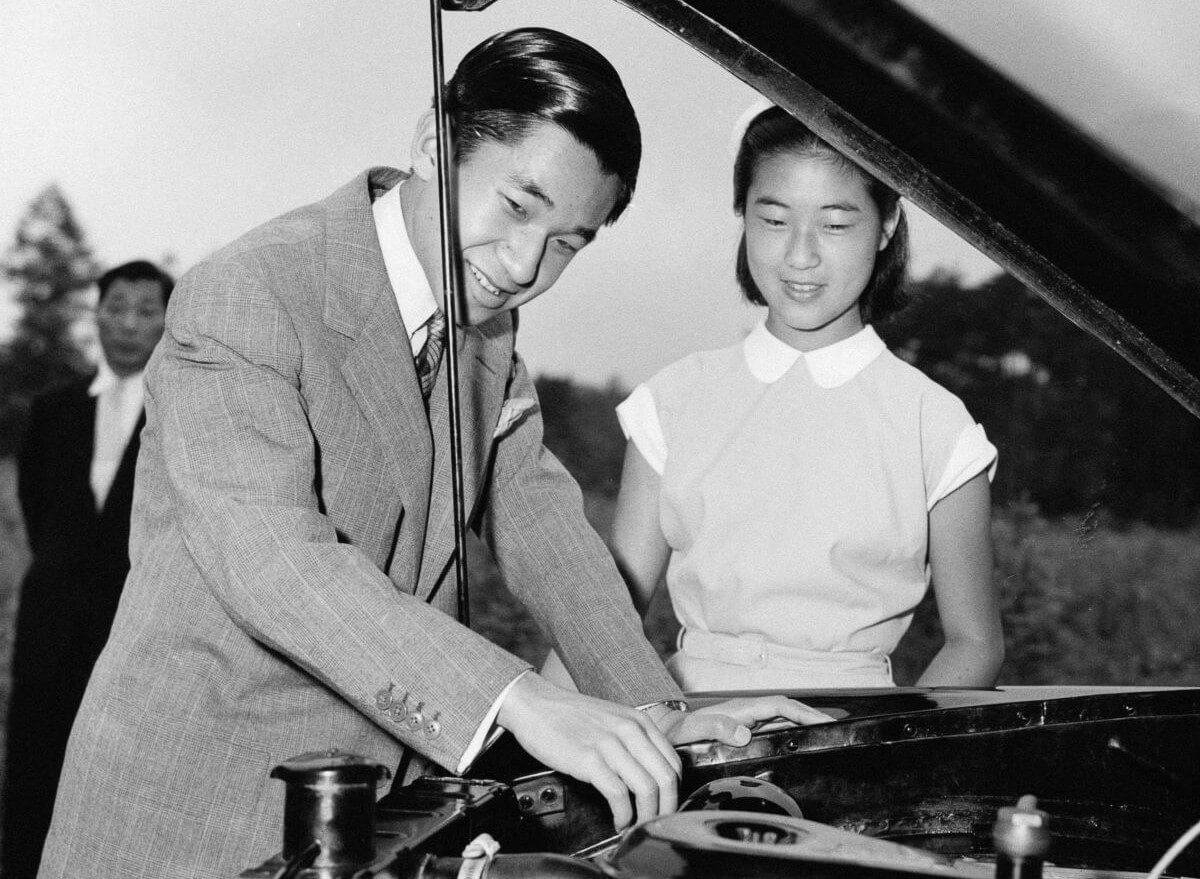 Prince Takako (R) watching her brother Prince Akihito (L) working on the engine of his 1954 Prince Motor Company car