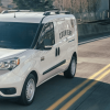 A 2022 Ram ProMaster City panel van/commercial vehicle model in white driving past concrete guard rails