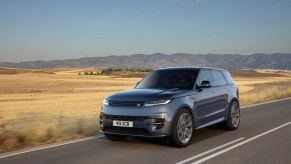 The 2024 Land Rover Range Rover Sport driving down a desert road in gray.