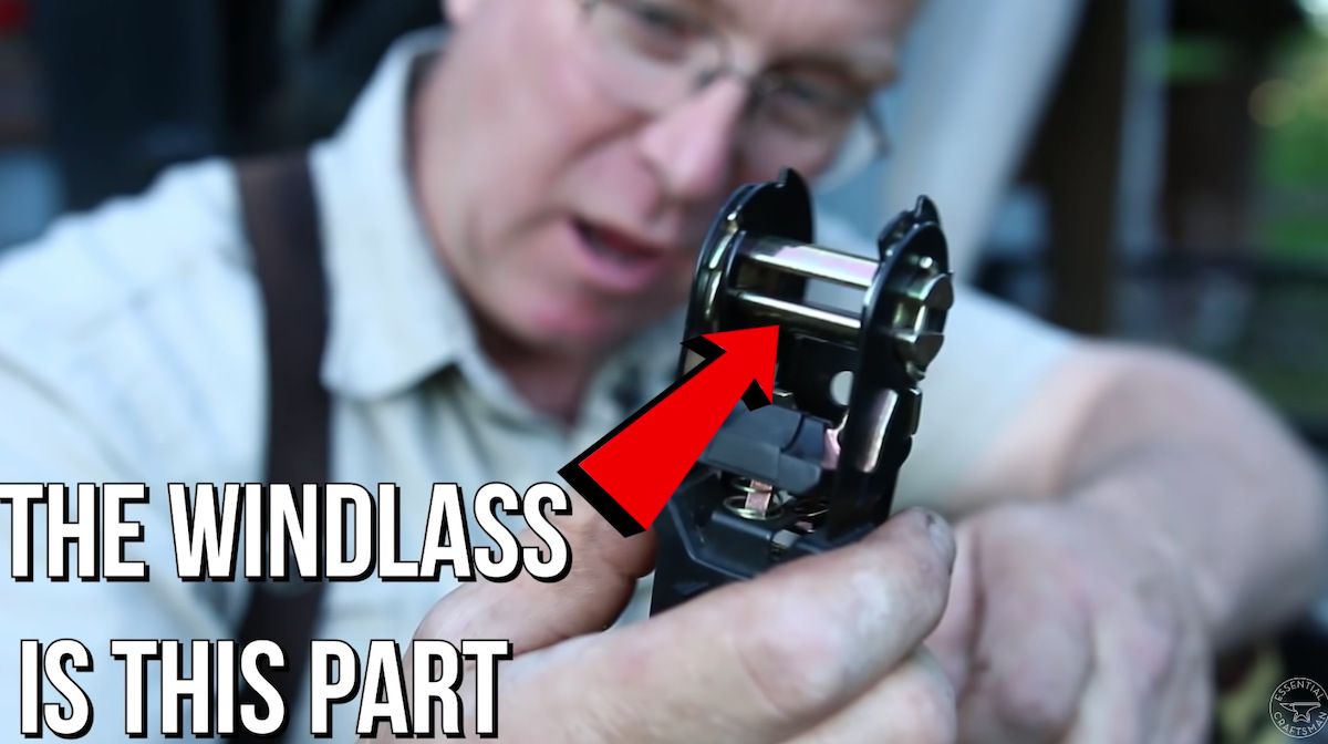 A Screen shot of a man showing how to use a ratchet strap