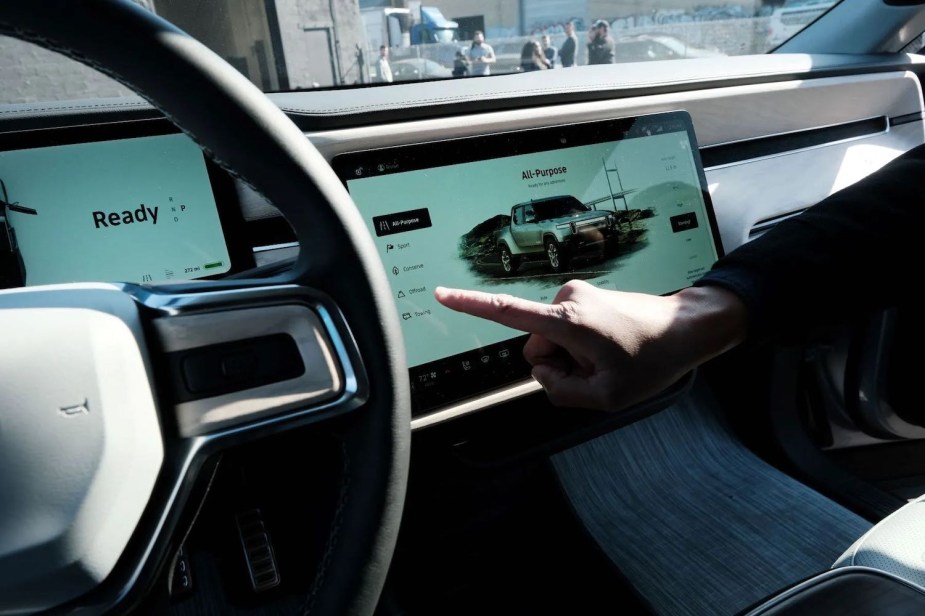 A person uses the touchscreen in a Rivian R1T electric vehicle EV.