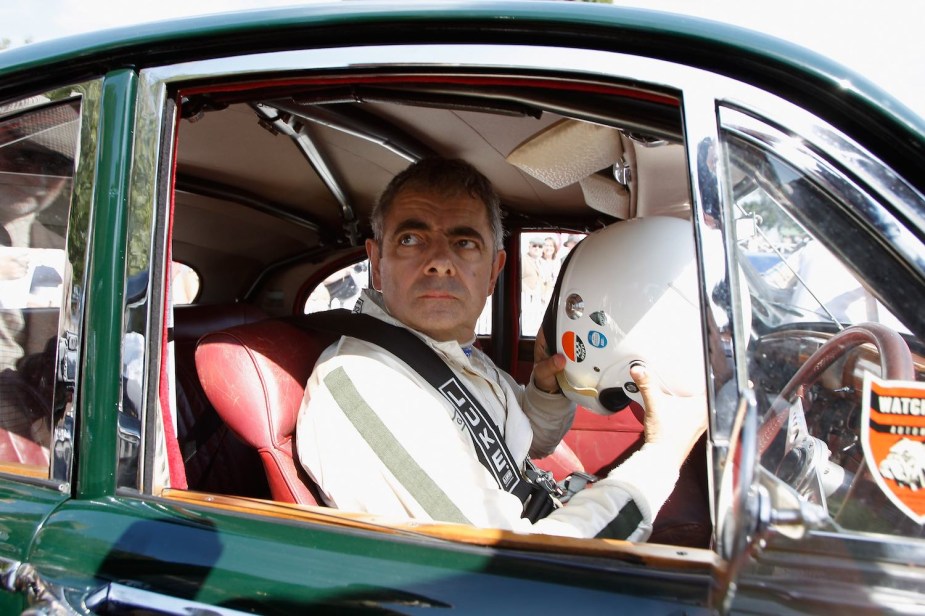Actor Rowan Atkinson races a vintage car at the Goodwood Revival event.