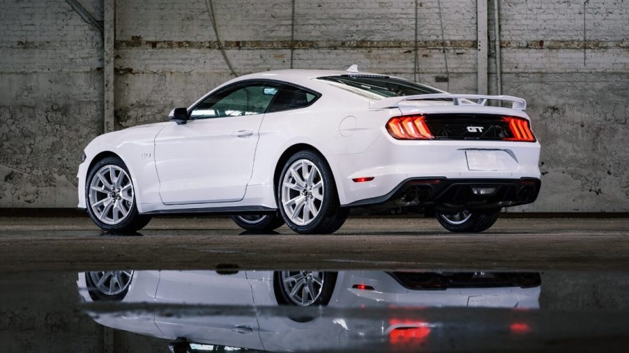 A white Ford Mustang GT Coupe sports car reflects.
