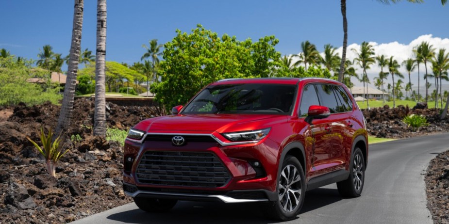 A red 2024 Toyota Grand Highlander midsize SUV is parked.