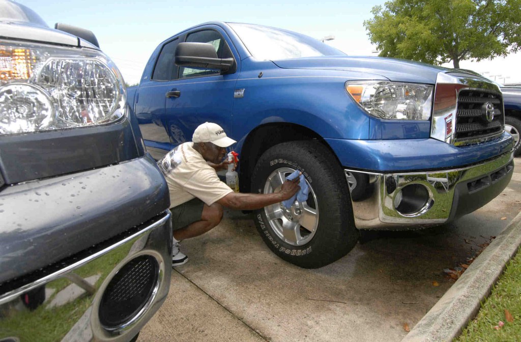 A man cleaning the wheels of a 2009 Toyota Tundra