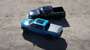 This is a Ram 1500 Rebel and Toyota Tundra Limited next to one another in a gravel parking lot.