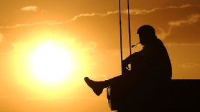 A marine sits on a U.S. Military armored vehicle.