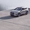 A 2023 Volvo XC60 Recharge plug-in hybrid (PHEV) compact luxury SUV model parked on a concrete dock by water