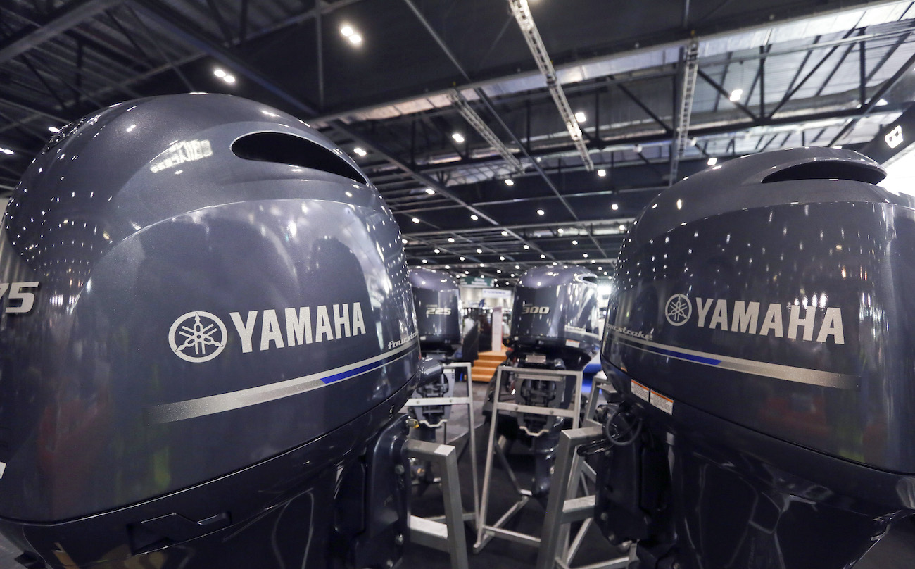 Logos sit on the engine fairings of outboard motor boat engines, manufactured by Yamaha Motor Co., stand on display ahead of the 2014 London Boat Show