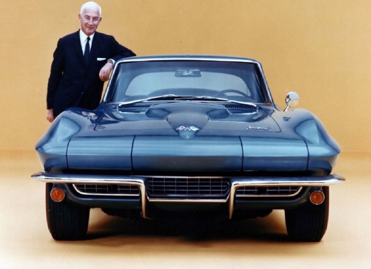 Zora Arkus-Duntov stands with a blue Chevrolet Corvette C2.