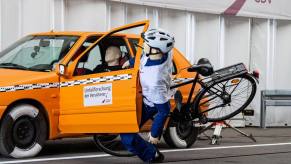 A crash safety test simulating a 'dooring' accident with a cyclist dummy
