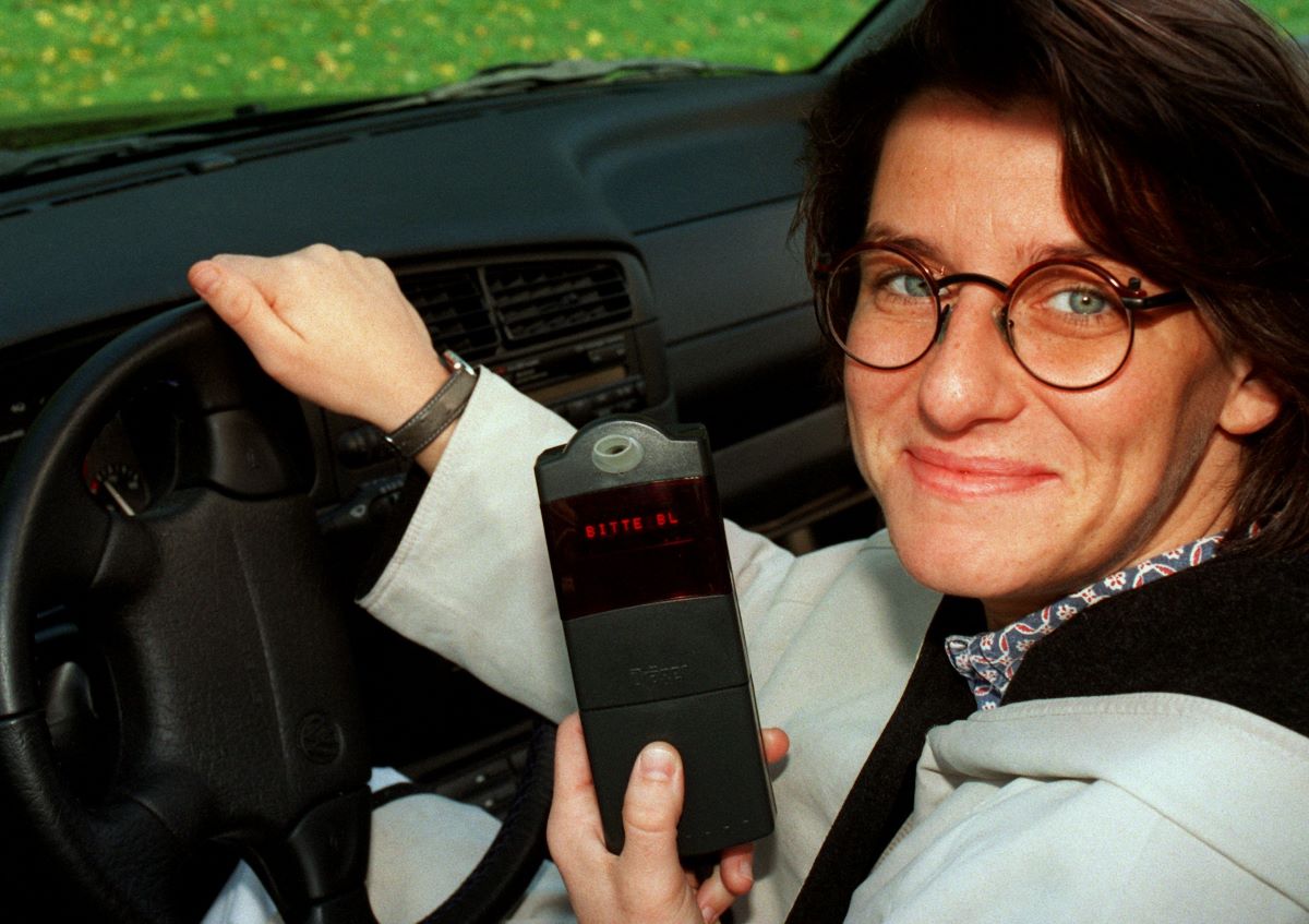 Touring car driver Ellen Lohr holding an electronic car immobilizer connected to the vehicle's ignition