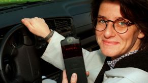 Touring car driver Ellen Lohr holding an electronic car immobilizer connected to the vehicle's ignition