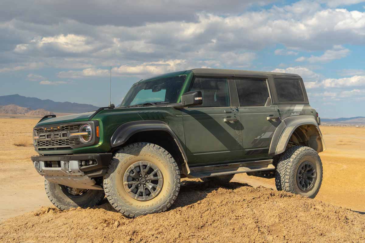 Green Ford Bronco Raptor in the California Desert sitting on top of dirth ill