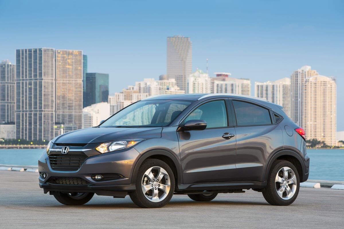A gray 2017 Honda HR-V subcompact SUV model parked near water with a city skyline in the background