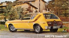 A postcard advertisement of a yellow AMC Gremlin X compact car hatchback sedan from 1974