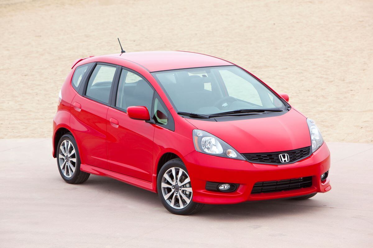 A 2013 Honda Fit Sport hatchback model in red, the Fit is available with both an automatic and manual transmission