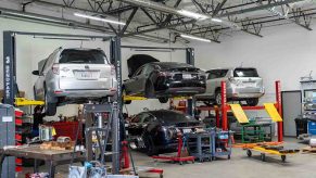 Toyota RAV4 EV and Tesla Model S on Lift inside Electric Car Repair Shop