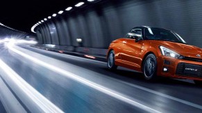 Toyota Daihatsu Copen GR Sport Convertible driving through a tunnel at night in bright orange sports car