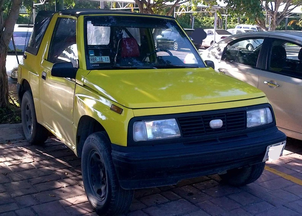 A yellow Geo Tracker parked in the shade