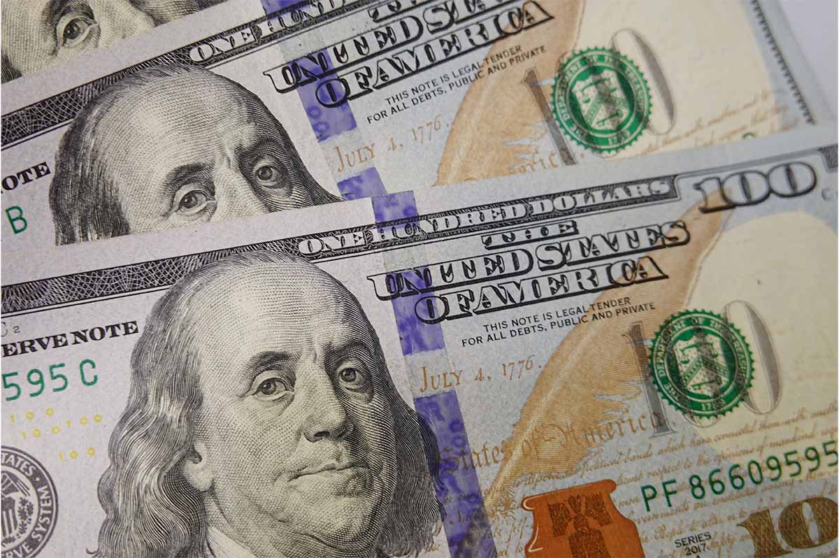A stack of U.S. $100 bills with Benjamin Franklin on them
