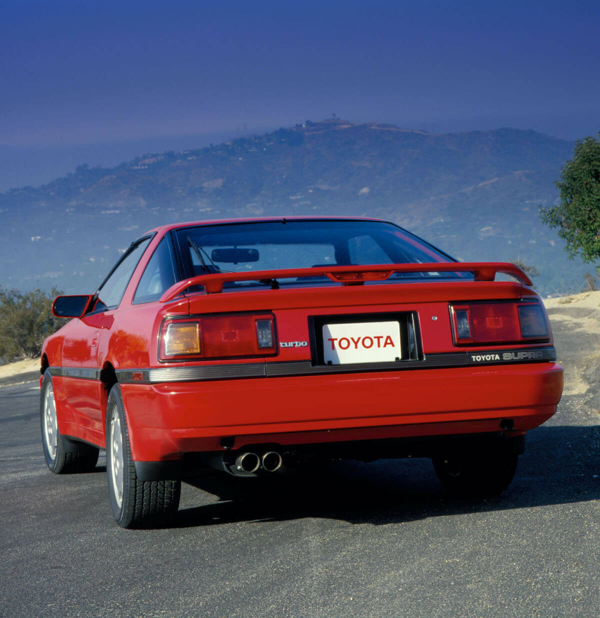 A rear view of a red 1987 Toyota Supra