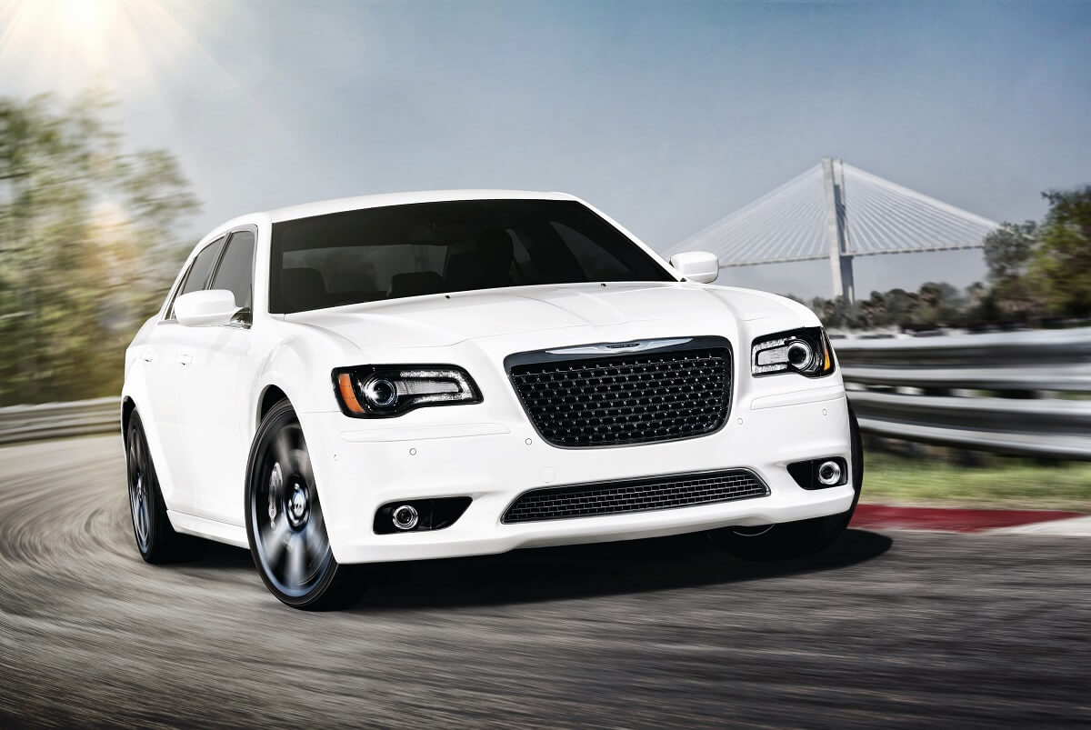 A white 2012 Chrysler 300 SRT8 shows off its front-end styling while it hits a track.