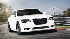 A white 2012 Chrysler 300 SRT8 shows off its front-end styling while it hits a track.