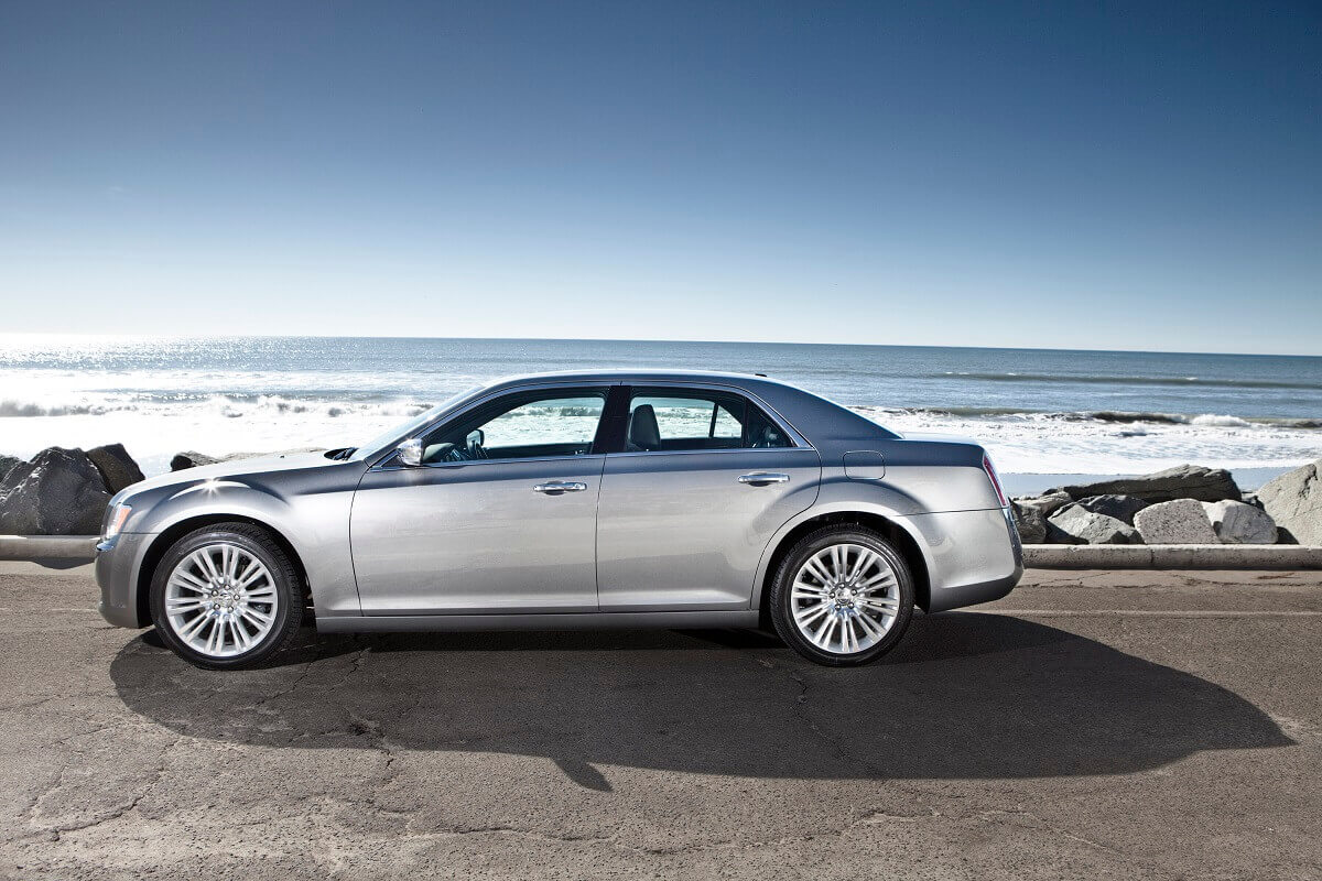 A silver 2014 Chrysler 300 parks by the coast.
