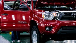 A worker checks over a used Toyota Tacoma in the final production line before driving the truck out of the factory at the Toyota Motor Manufacturing Texas