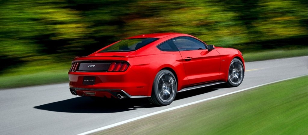 A red 2015 Ford Mustang GT turns premium gas into noise as it blasts down a country road.