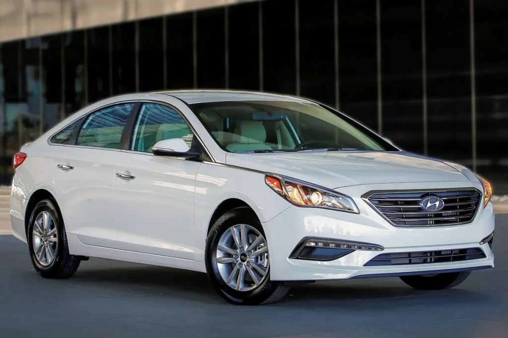White 2016 Hyundai Sonata sedan against building